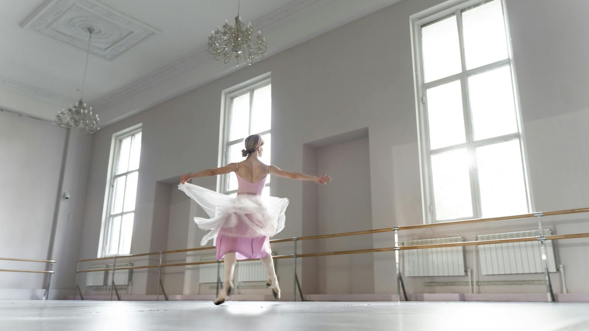 Serene woman practicing morning movements in a sunlit studio
